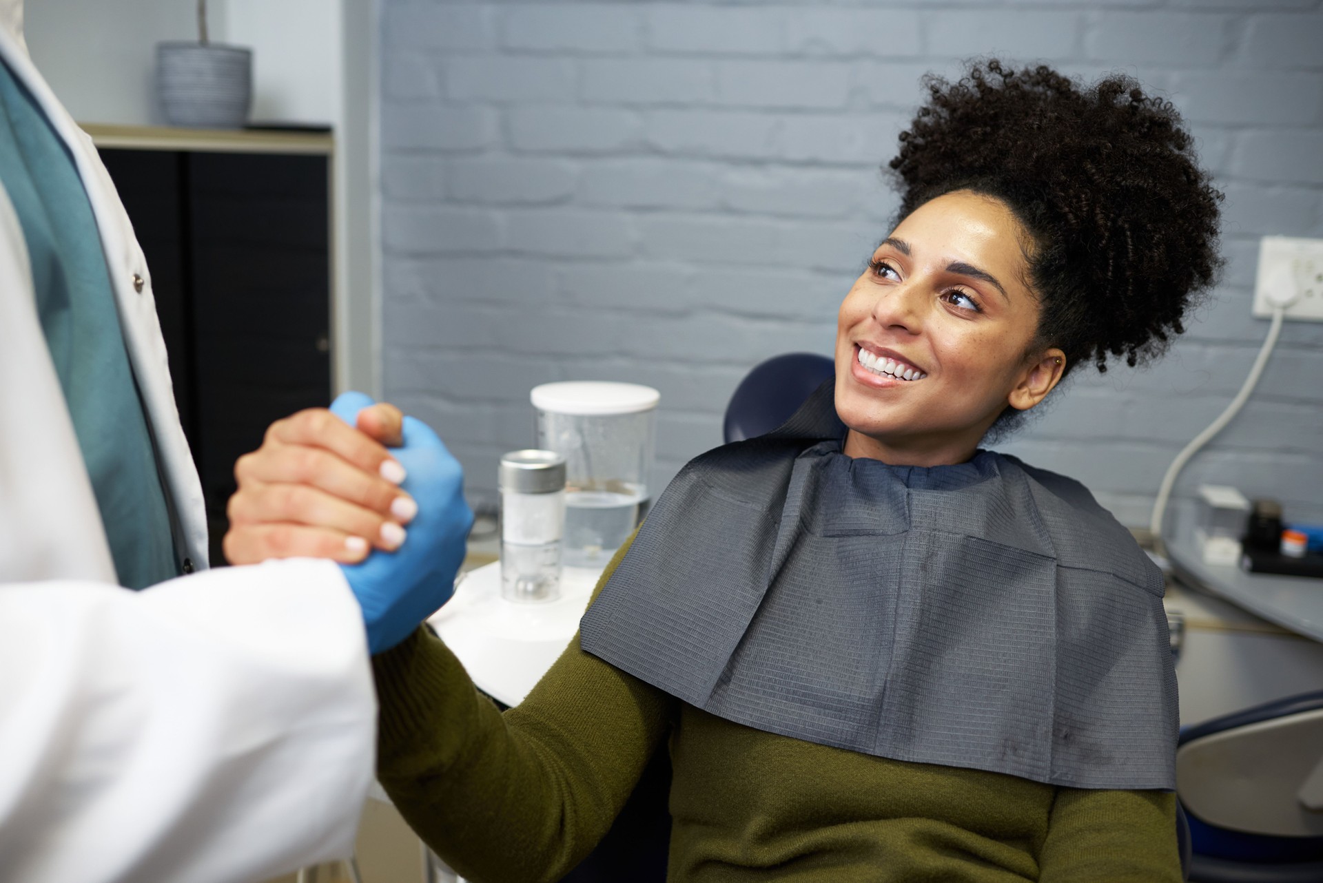 Smiling Patient Receiving Care During a Dentist Appointment and Shaking Hands With the Dentist